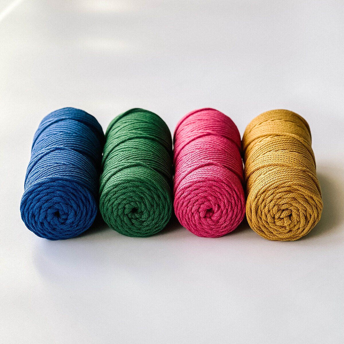 Zestaw 4 sznurków plecionych do makramy o grubości 5 mm z rdzeniem bawełnianym. Kolory: indygo, soczysty zielony, magenta, miodowy.